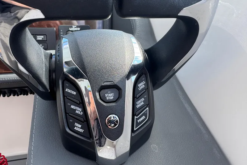 Slide: The Image of 2024 Chaparral 280 OSX boat control panel with steering wheel and buttons. - 82