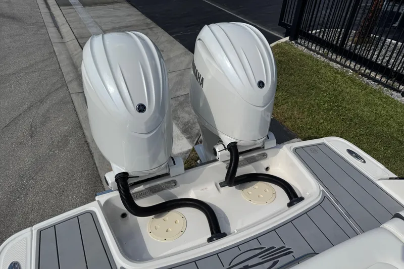 Slide: The Image of 2024 Chaparral 280 OSX boat with dual Yamaha outboard engines, docked on a sunny day. - 95