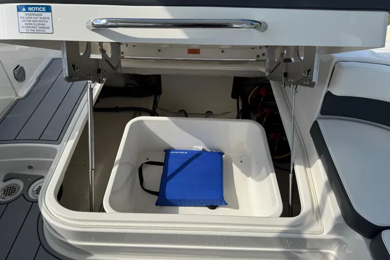 Slide: The Image of 2024 Chaparral 280 OSX boat storage compartment with blue bag inside. - 97