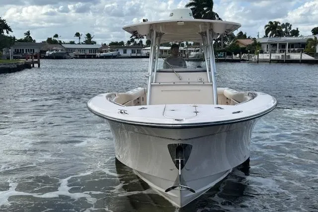 Slide: The Image of 2007 Grady-White Bimini 306 boat on water, front view, with houses in the background. - 1
