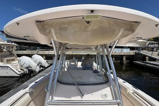 Slide: The Image of 2007 Grady-White Bimini 306 boat docked, featuring a spacious helm and T-top canopy. - 32