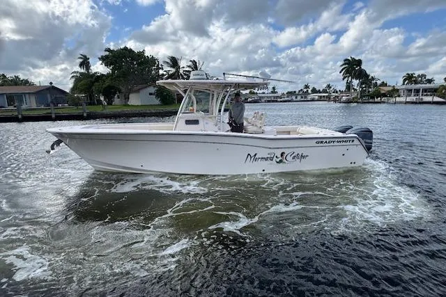 Slide: The Image of 2007 Grady-White Bimini 306 boat cruising on a scenic waterway under cloudy skies. - 4