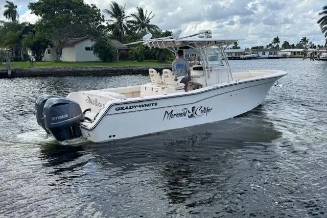 Slide: The Image of 2007 Grady-White Bimini 306 boat on water, featuring Yamaha engines, cruising near palm trees. - 8