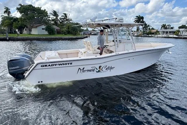 Slide: The Image of 2007 Grady-White Bimini 306 boat named "Mermaid Catcher" cruising on a scenic waterway. - 9