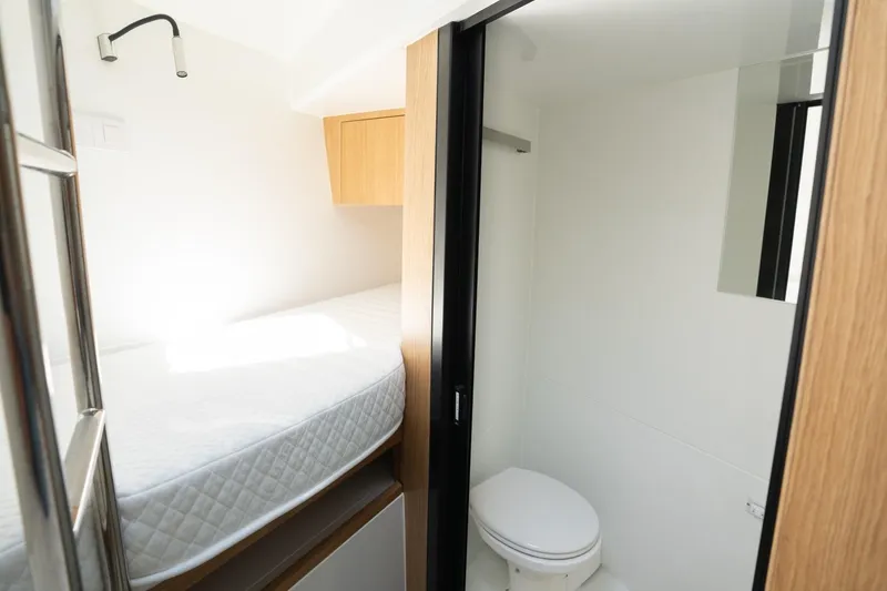 Slide: The Image of Interior of 2026 De Antonio Yachts D60, featuring a compact bedroom and bathroom. - 34