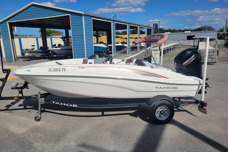 The Image of 2022 Tahoe T16 boat on trailer, parked outdoors under clear sky. - 1