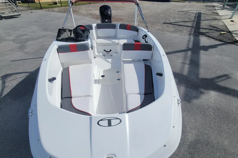 Slide: The Image of 2022 Tahoe T16 boat with white and red seating, parked on pavement. - 10