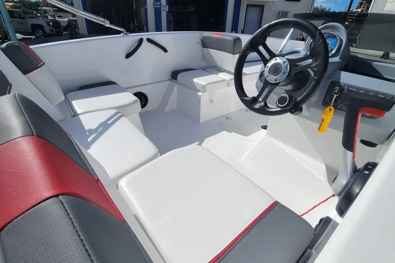 Slide: The Image of 2022 Tahoe T16 boat interior with steering wheel and seating, featuring red and black accents. - 12