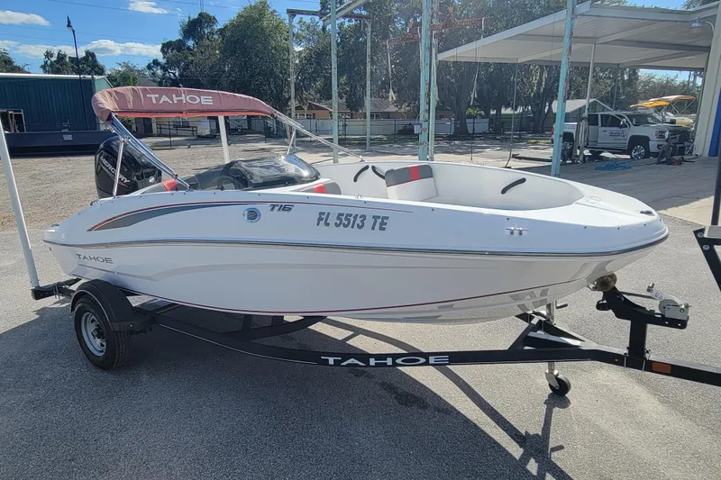 Slide: The Image of 2022 Tahoe T16 boat on trailer with canopy, parked outdoors. - 3