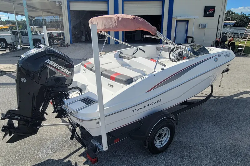 Slide: The Image of 2022 Tahoe T16 boat with Mercury engine on trailer, parked outside a building. - 4