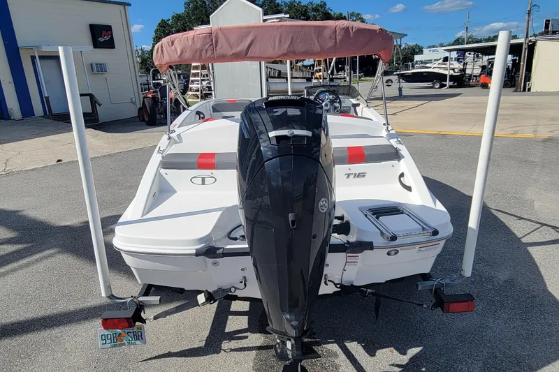 Slide: The Image of 2022 Tahoe T16 boat with Mercury engine, parked outdoors on a sunny day. - 5