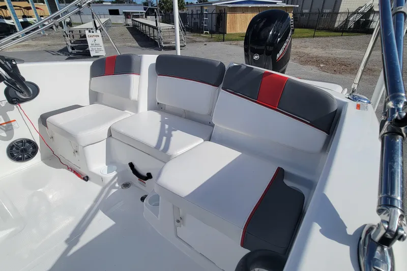 Slide: The Image of 2022 Tahoe T16 boat interior with white and gray seating, red accents, and Mercury engine. - 7