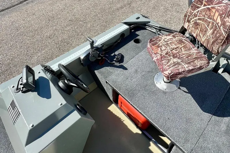 Slide: The Image of 2004 MirroCraft 1876 Outfitter boat interior with camo seat and steering console. - 21