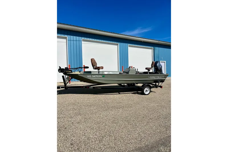 Slide: The Image of 2004 MirroCraft 1876 Outfitter boat on trailer, parked outside blue building. - 26