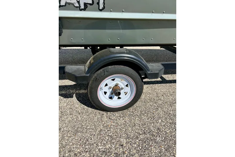 Slide: The Image of Trailer wheel of 2004 MirroCraft 1876 Outfitter boat on asphalt surface. - 5
