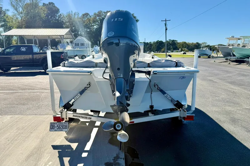 Slide: The Image of 2024 Lookout Bay 19 boat on trailer, parked outdoors under clear sky. - 2