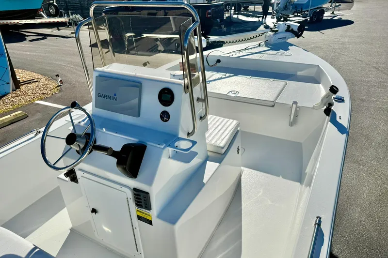 Slide: The Image of 2024 Lookout Bay 19 boat with Garmin navigation, sleek white design, and modern steering console. - 21