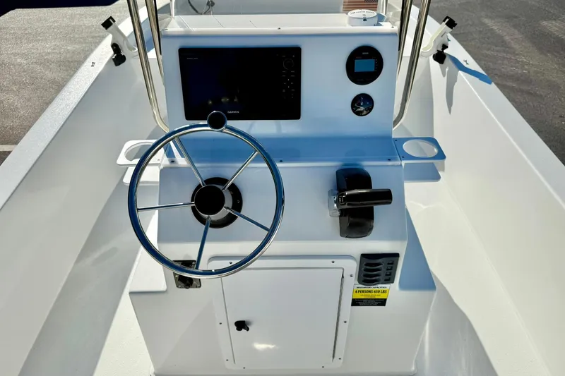 Slide: The Image of 2024 Lookout Bay 19 boat console with steering wheel and controls. - 23