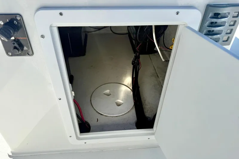 Slide: The Image of Open compartment on Lookout Bay 19 boat, showcasing interior wiring and storage space. - 25