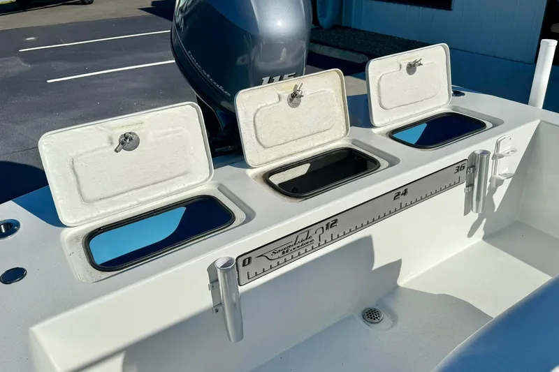 Slide: The Image of 2024 Lookout Bay 19 boat with open storage compartments and measurement scale. - 27