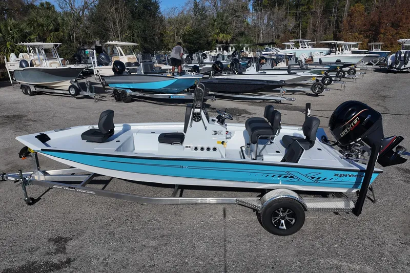 Slide: The Image of 2026 Xpress H20B Bay boat on trailer, parked outdoors with other boats. - 2