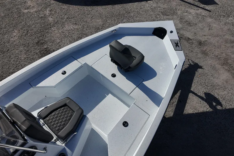 Slide: The Image of 2026 Xpress H20B Bay boat deck with seating, shown on a gravel surface. - 8