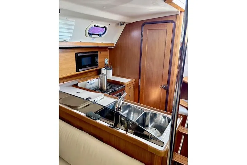 Slide: The Image of 2017 Catalina yacht interior kitchen with wooden cabinetry, stainless steel sink, and microwave. - 14