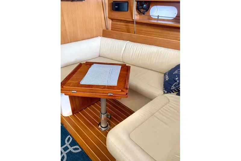 Slide: The Image of 2017 Catalina yacht interior with wooden table and cream leather seating. - 16