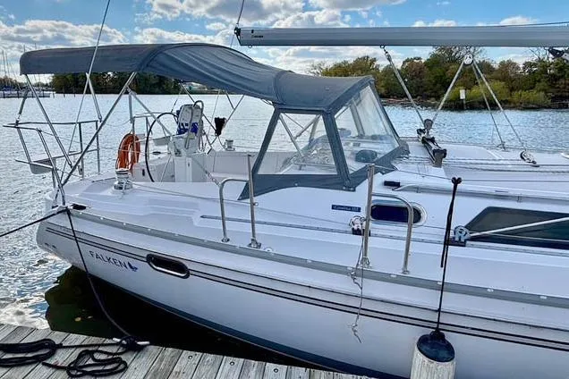 Slide: The Image of 2017 Catalina sailboat docked by a serene lake under a partly cloudy sky. - 2
