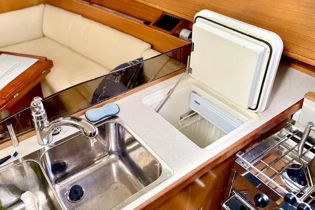 Slide: The Image of 2017 Catalina yacht kitchen with sink, fridge, and seating area. - 22