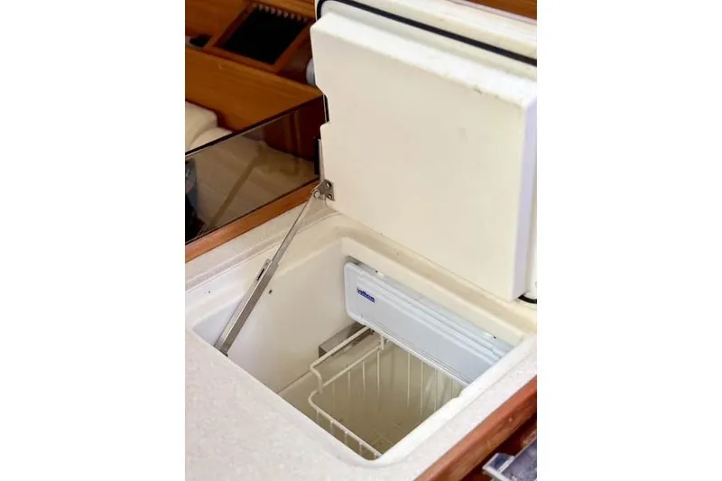 Slide: The Image of Open refrigerator in 2017 Catalina model boat interior, showcasing storage space. - 23