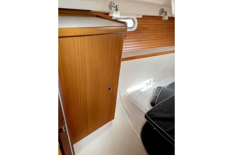 Slide: The Image of 2017 Catalina boat interior with wooden cabinet and cozy sleeping area. - 25