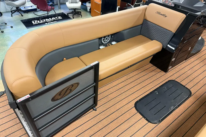 Slide: The Image of 2026 Bentley Pontoons Elite 253 Swingback Dual Capt interior with tan and gray seating. - 1