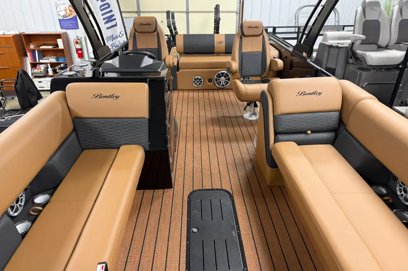 Slide: The Image of 2026 Bentley Pontoons Elite 253 Swingback Dual Capt interior with tan and gray seating. - 3