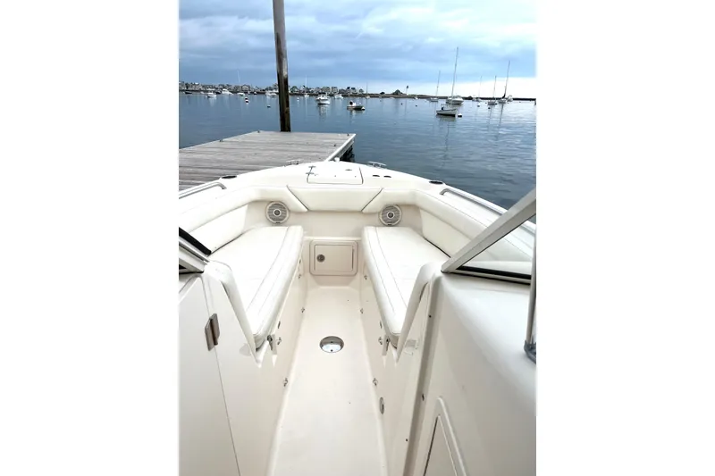 Slide: The Image of 2018 Grady-White Freedom 275 boat interior at dock, calm water, and moored boats. - 11
