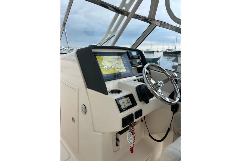 Slide: The Image of 2018 Grady-White Freedom 275 boat dashboard with steering wheel and navigation display. - 15