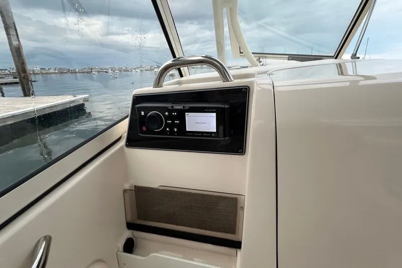 Slide: The Image of 2018 Grady-White Freedom 275 boat interior with Fusion audio system, docked by calm waters. - 18