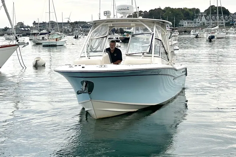 Slide: The Image of 2018 Grady-White Freedom 275 boat on calm water, surrounded by other vessels. - 2