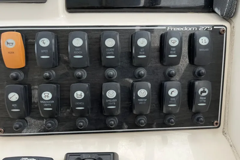 Slide: The Image of Control panel of a 2018 Grady-White Freedom 275 boat with labeled switches. - 23