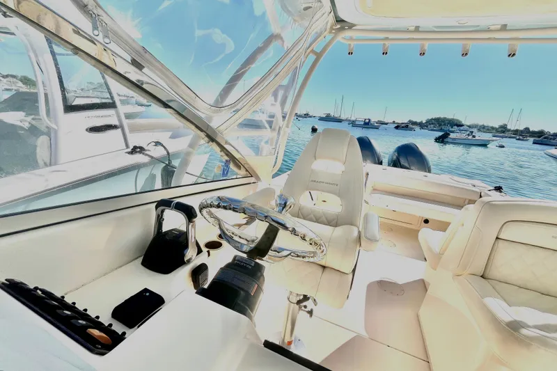 Slide: The Image of 2018 Grady-White Freedom 275 boat interior with steering wheel, seats, and ocean view. - 24