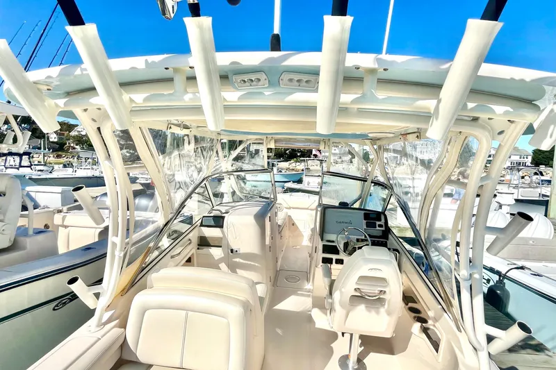 Slide: The Image of 2018 Grady-White Freedom 275 boat interior with helm, seating, and fishing rod holders. - 25