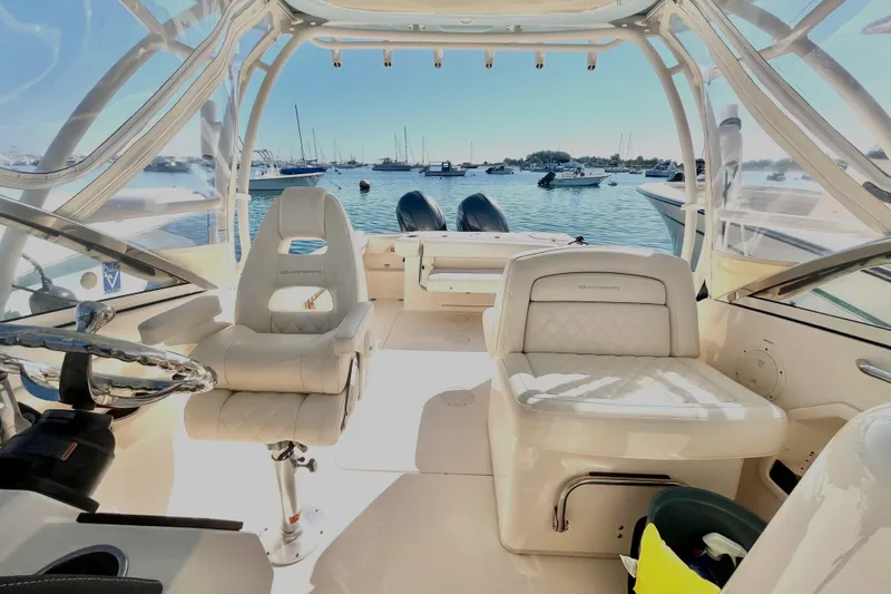 Slide: The Image of 2018 Grady-White Freedom 275 boat interior with seating, steering wheel, and ocean view. - 26