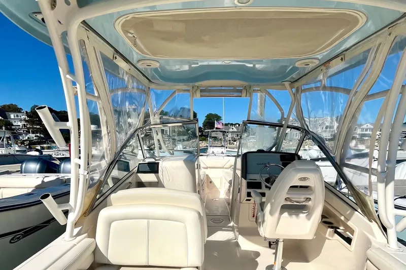 Slide: The Image of 2018 Grady-White Freedom 275 boat interior with helm, seating, and clear canopy. - 27