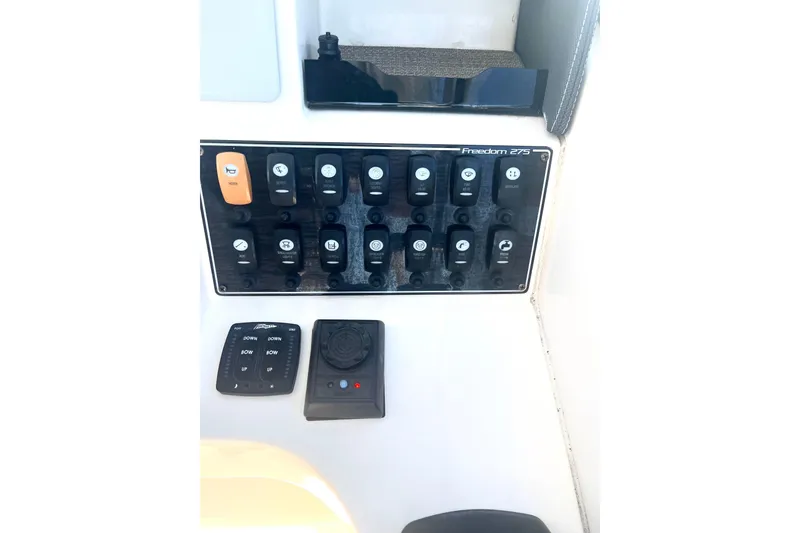 Slide: The Image of Control panel of 2018 Grady-White Freedom 275 boat with various switches and controls. - 40