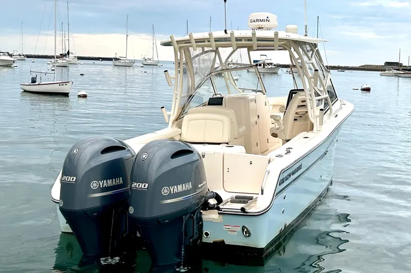 Slide: The Image of 2018 Grady-White Freedom 275 boat with twin Yamaha engines in a serene harbor setting. - 8