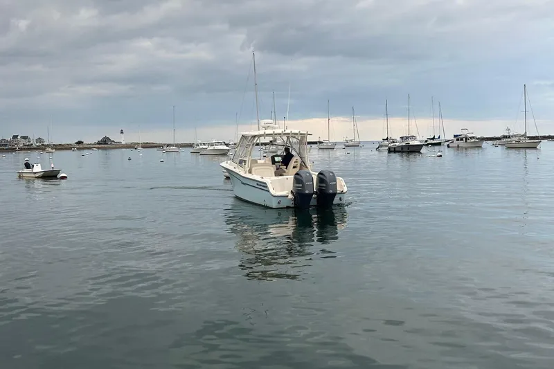 Slide: The Image of 2018 Grady-White Freedom 275 boat on calm water, surrounded by other boats. - 9