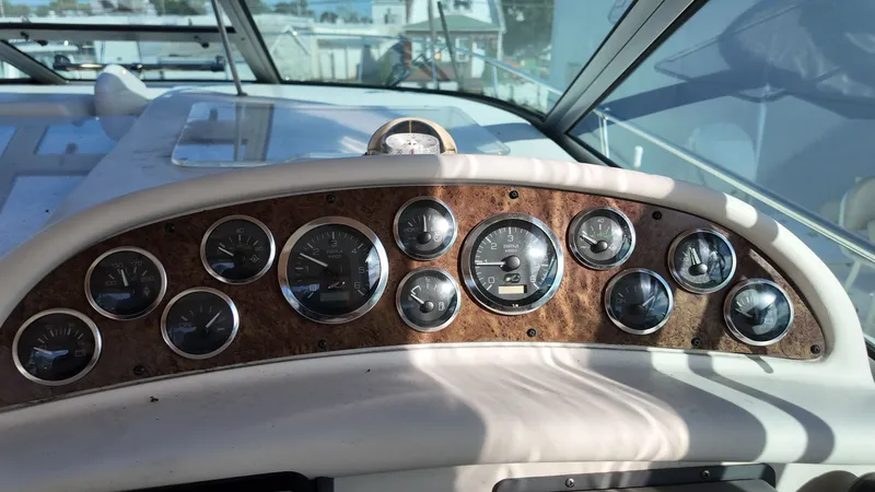 Slide: The Image of Dashboard of a 2001 Sea Ray 290 Sundancer boat with multiple gauges and controls. - 15