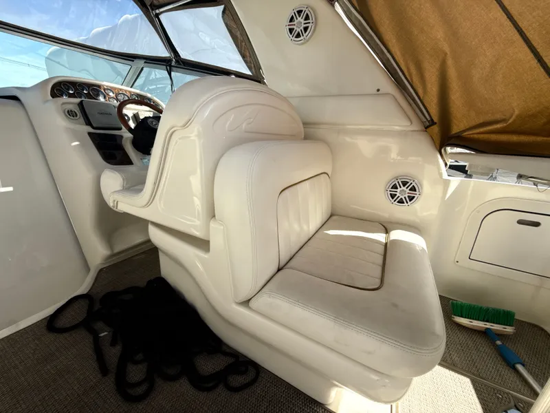 Slide: The Image of 2001 Sea Ray 290 Sundancer helm with white seating and dashboard controls. - 17