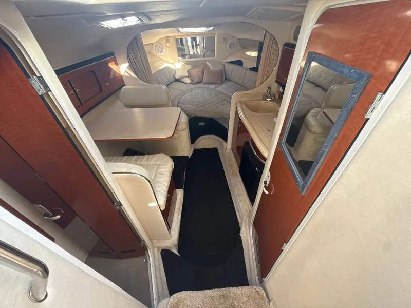 Slide: The Image of Interior of 2001 Sea Ray 290 Sundancer boat, featuring cozy seating and compact kitchenette. - 18