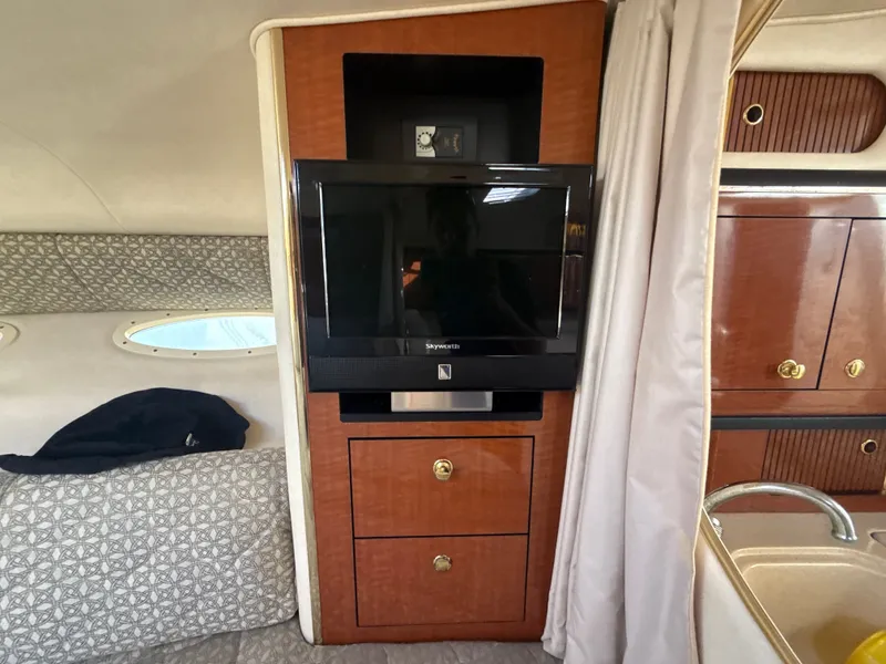 Slide: The Image of Interior of 2001 Sea Ray 290 Sundancer with TV, wooden cabinetry, and porthole window. - 20
